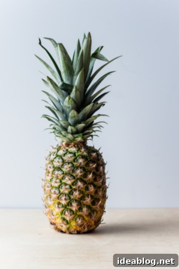 Honey-Glazed Pineapple with Pistachio Crumble 4 Whole, uncut pineapple on a wooden board