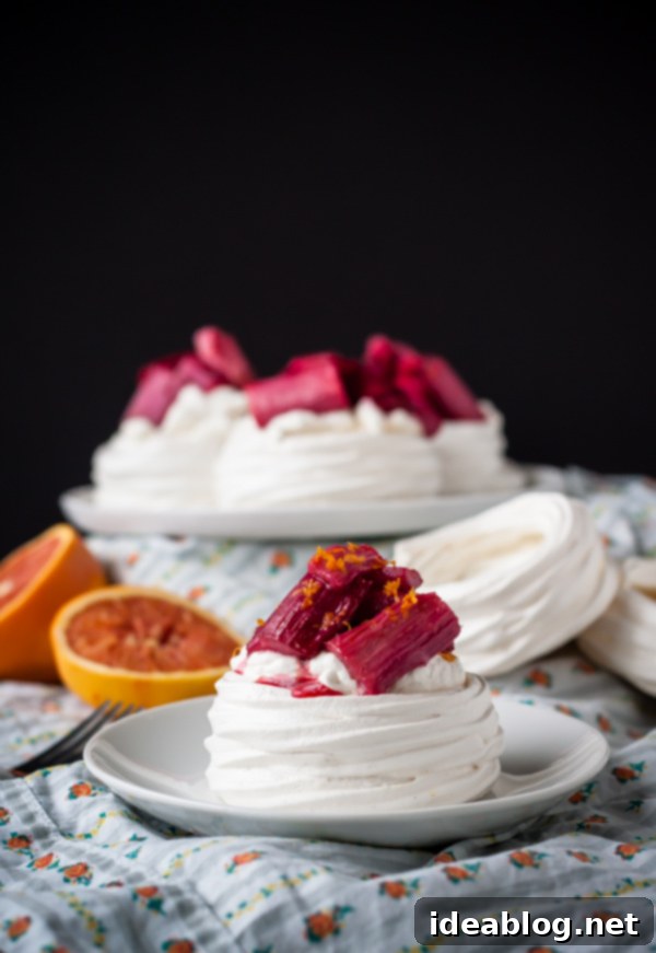 Homemade meringue cups are filled with vanilla bean whipped cream and roasted rhubarb. The perfect spring dessert! Close-up of Rhubarb Meringue Cups