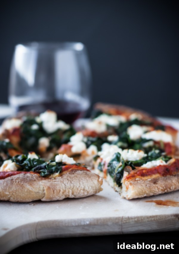 Fiery Feta Skillet Pizza 3 A tempting close-up of a slice of Harissa, Spinach, and Feta Skillet Pizza, revealing its golden-brown crust, melted feta, and tender greens, promising a burst of flavor.
