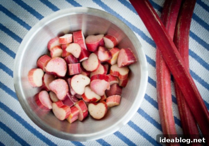 Homestyle Rhubarb Compote 3 Freshly chopped rhubarb on a wooden cutting board, prepped and ready for cooking into a compote.
