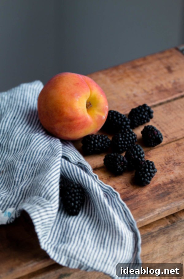 Sun-Kissed Blackberry Peach Delight 5 Ingredients for Blackberry Peach Pie, including fresh peaches, blackberries, flour, sugar, and cold butter, laid out on a countertop