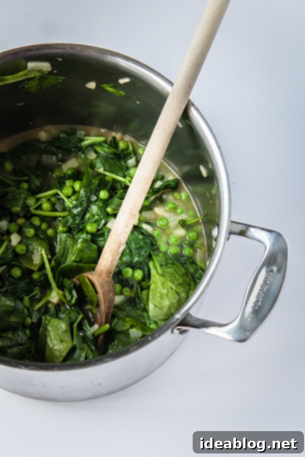 Garden Fresh Spinach Soup with Minted Peas and Cilantro 4 Fresh Spinach Soup with Minted Pea and Cilantro served in a bowl with a spoon