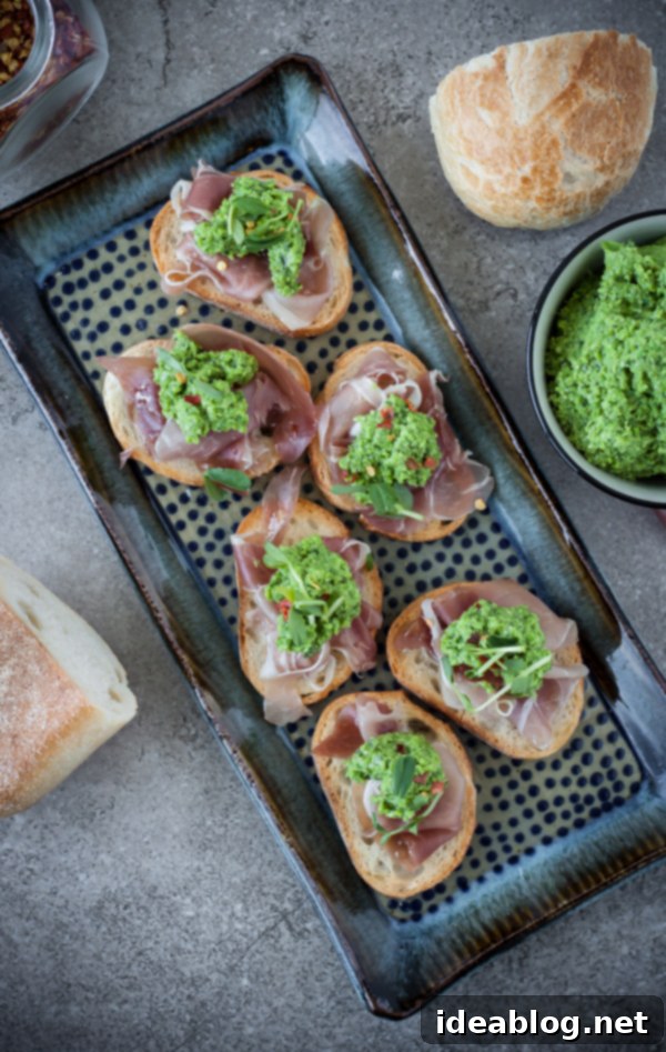 Sweet Pea and Prosciutto Crostini Bites 5 Pea Pesto Crostini with Prosciutto on Ceramic Tray
