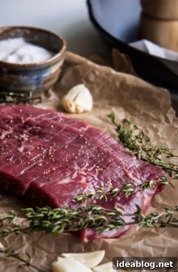 Butter Basted Flank Steak - a simple flank steak recipe basted with butter and fresh herbs. Serve with salad or bulk it up by serving it with roasted fingerling potatoes and sautéed greens or asparagus. #beef #abeautifulplate #recipe #flanksteak #steakrecipe #herbs Raw Flank Steak Seasoned with Salt and Pepper