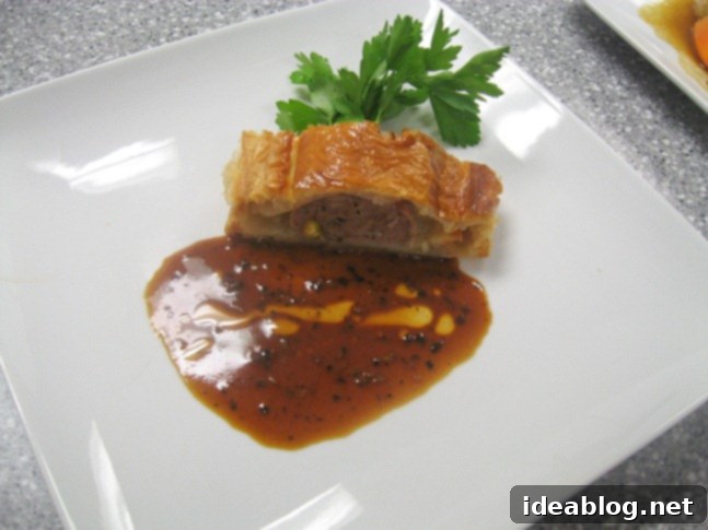 A Two-Day Culinary Journey: Pate, Merguez, Rack of Lamb, and Le Fraisier 3 A perfectly sliced portion of duck pate with truffle sauce, showcasing its layers.