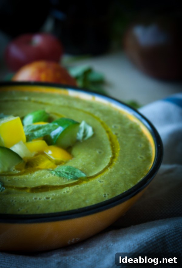 Velvety Heirloom Tomato and Avocado Gazpacho 4 Heirloom Tomato and Avocado Gazpacho in a clear bowl, garnished with herbs