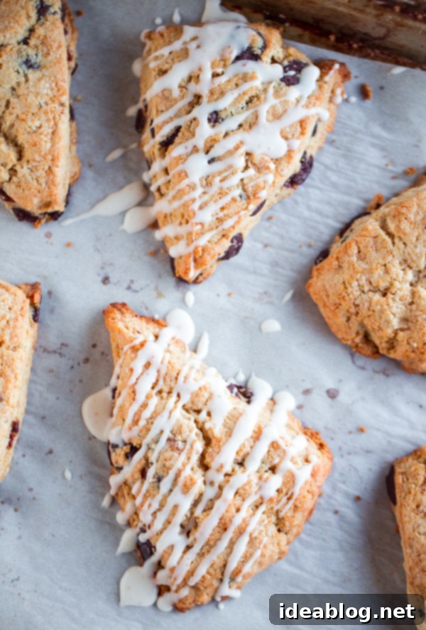 Toasted Butter Chocolate Chip Scones 6 Beautifully arranged Brown Butter Chocolate Chip Scones, some with a glistening glaze, others plain, presented on a platter.
