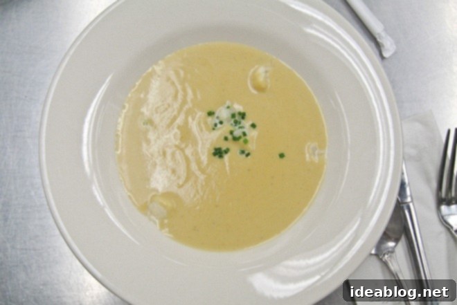 Day 40's Delight: Cauliflower Soup, Grilled Salmon, and Madeleines 2 A bowl of creamy, rich Cauliflower Soup, garnished lightly, served as an elegant appetizer in a culinary class setting.