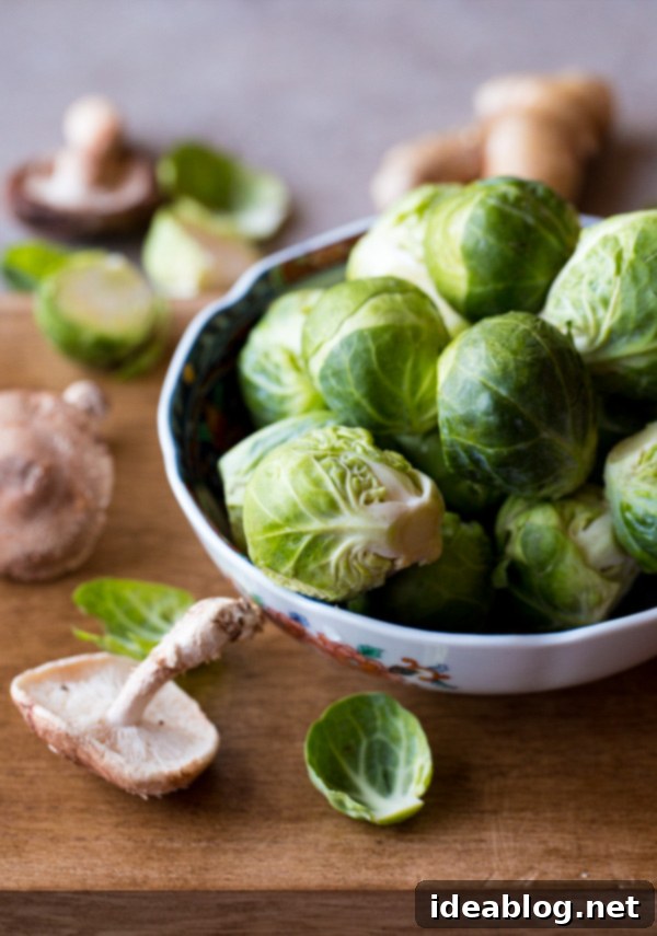 Savory Asian Brussels Sprouts with Crispy Shiitake 3 Fresh, whole Brussels sprouts waiting to be trimmed and halved for roasting.