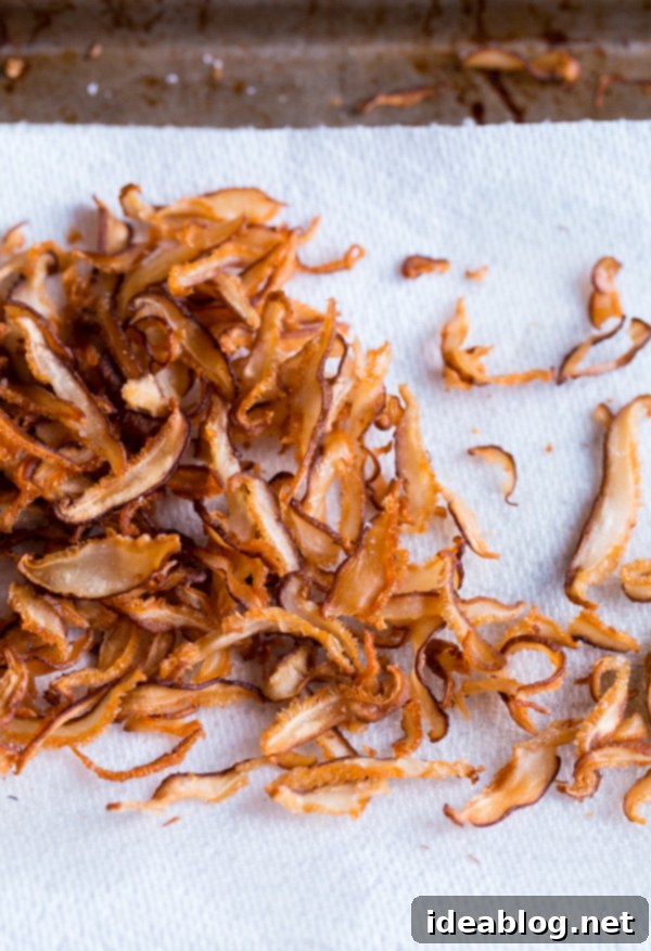 Savory Asian Brussels Sprouts with Crispy Shiitake 5 Golden-brown, crispy fried shiitake mushrooms draining on paper towels, seasoned with salt.
