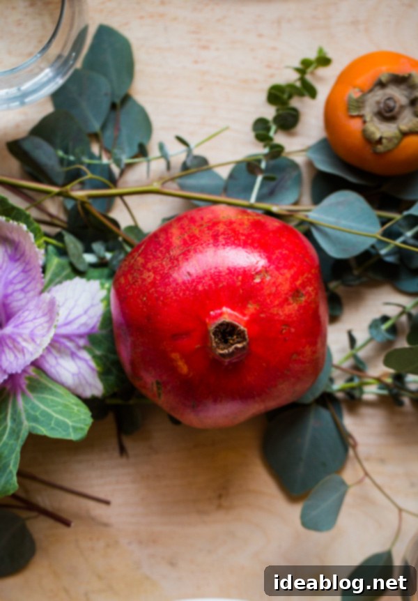 Your Instant Holiday Table Sparkle 4 Close-up of fresh pomegranates, persimmons, cranberries, and eucalyptus in a holiday centerpiece