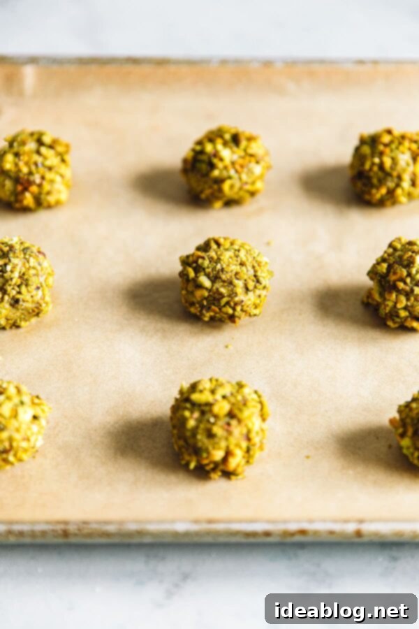 Jam-Filled Pistachio Thumbprint Cookies 6 Thumbprint cookie dough balls rolled in crushed pistachios, ready for baking