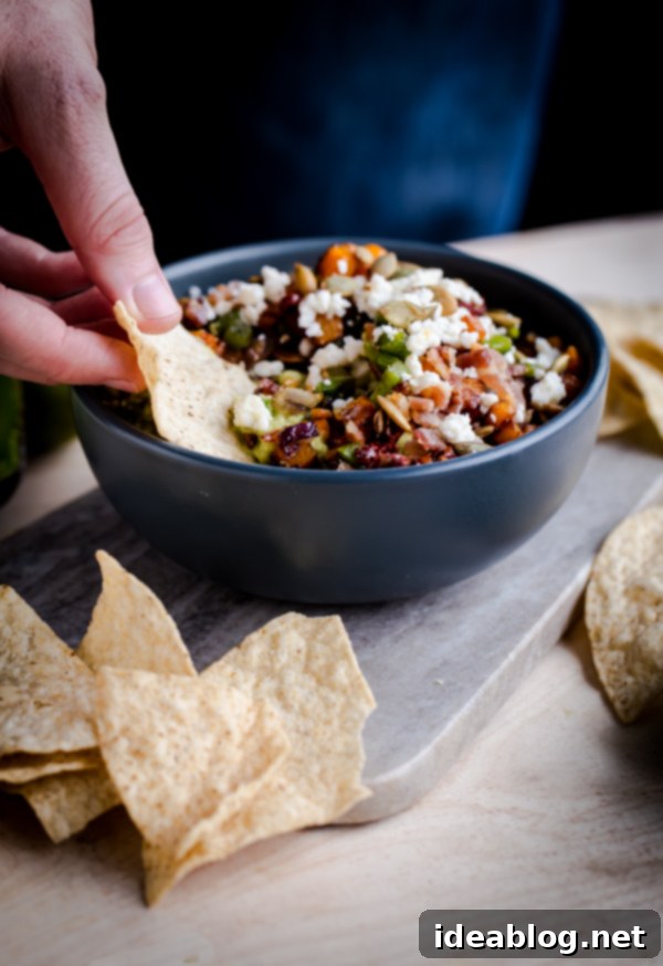 The Ultimate Guacamole 4 A beautifully presented bowl of gourmet Fully Loaded Guacamole, garnished with fresh, vibrant toppings, ready to be enjoyed.