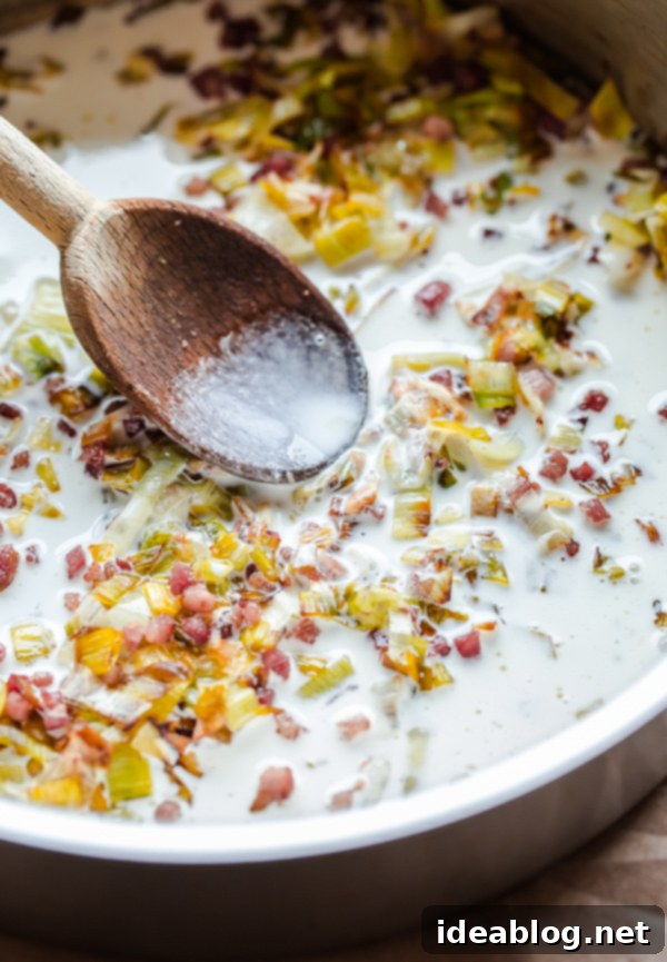 Sautéing leeks for the creamy pasta sauce base Creamy pasta sauce with leeks and pancetta simmering in a skillet