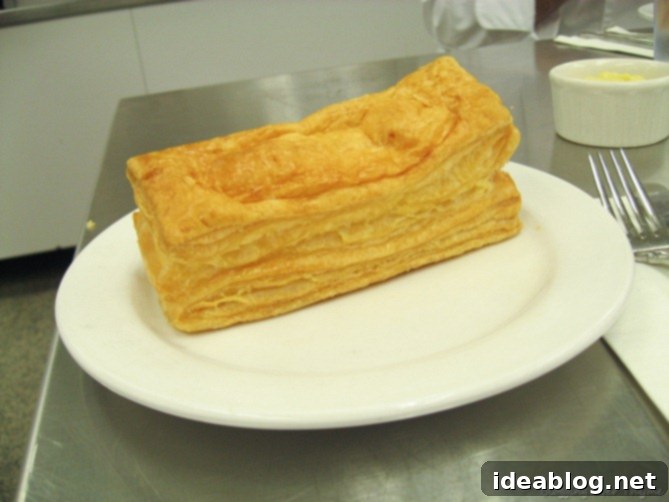 Day 16: French Bistro Delights 11 A freshly baked, golden-brown puff pastry cheese stick, showcasing its incredible height and flaky texture.