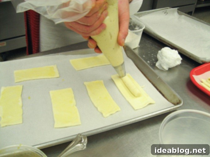 Day 16: French Bistro Delights 8 Two puff pastry rectangles, one topped with rich Mornay cheese sauce, demonstrating the precise assembly for L'Allumette au Fromage.