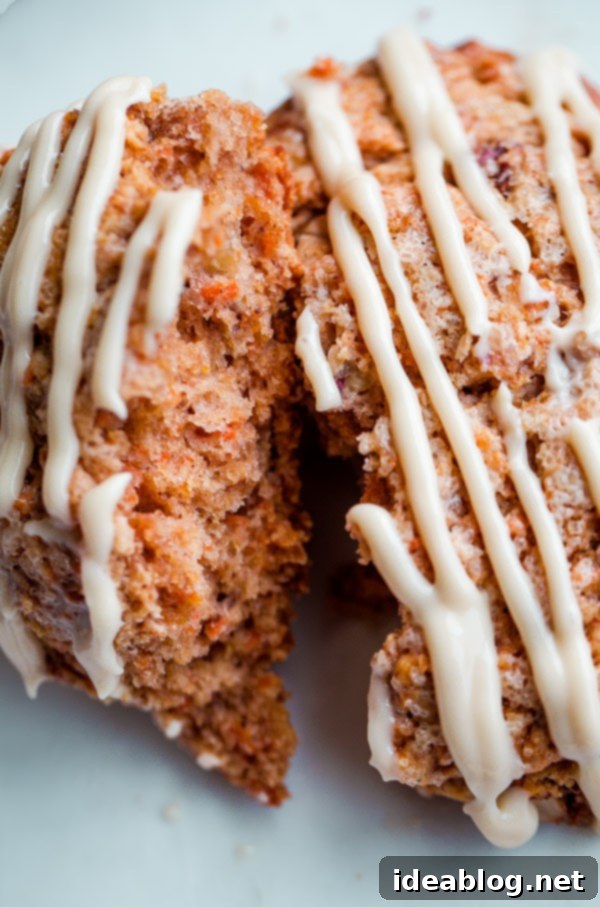 Spiced Carrot Cake Scones with Maple Cream Cheese Glaze 7 A tray of freshly baked Carrot Cake Scones cooling on a wire rack, intricately drizzled with maple cream cheese glaze