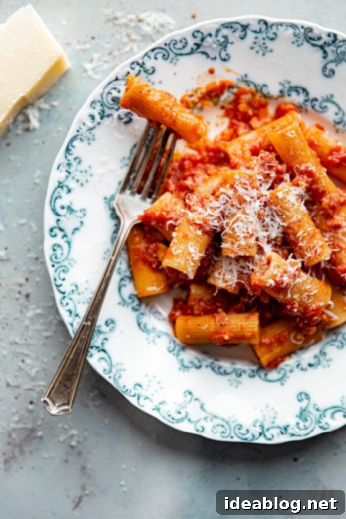 Amatriciana Pasta 6 A close-up shot of freshly prepared Pasta Amatriciana, generously topped with grated Pecorino Romano cheese and a hint of parsley.