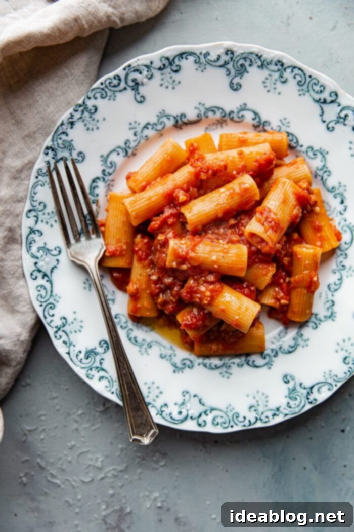 Amatriciana Pasta 10 A close-up of Rigatoni All Amatriciana being tossed in a skillet, coated with a rich red sauce and cheese.