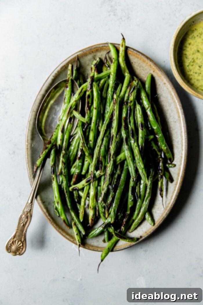 Fire-Kissed Green Beans with Zesty Cilantro Dressing 61 Charred Green Beans on Platter, garnished with fresh cilantro and lime wedges, perfect for a summer meal