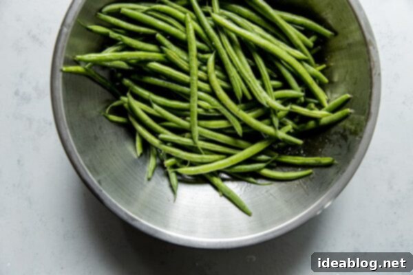 Fire-Kissed Green Beans with Zesty Cilantro Dressing 13 Green Beans Tossed with Olive oil in a bowl.