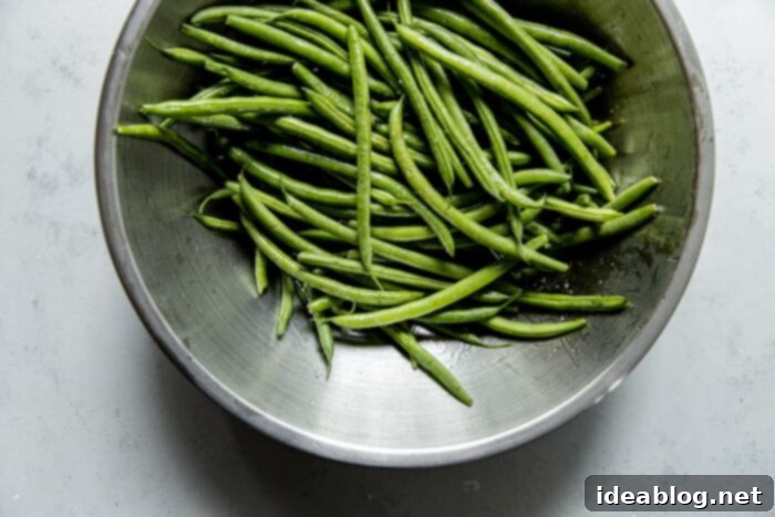 Fire-Kissed Green Beans with Zesty Cilantro Dressing 5 Green Beans Tossed with Olive oil and salt in a mixing bowl, ready for the grill.