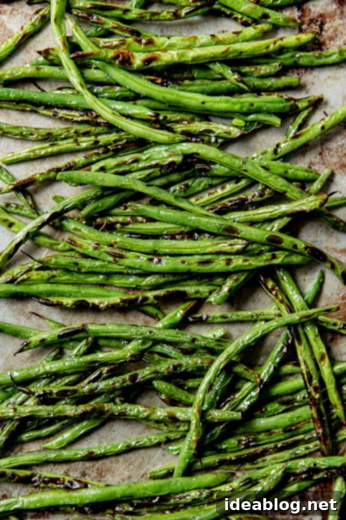 Fire-Kissed Green Beans with Zesty Cilantro Dressing 6 Close-up of perfectly charred green beans on a white platter.