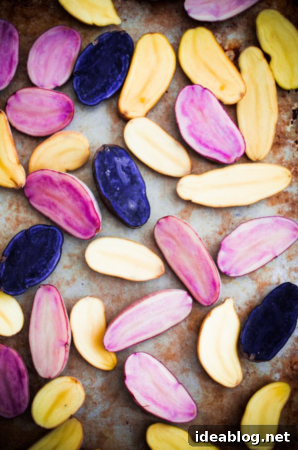 A beautiful display of yellow, red, and blue fingerling potatoes ready for cooking Colorful Fingerling Potatoes on a wooden cutting board