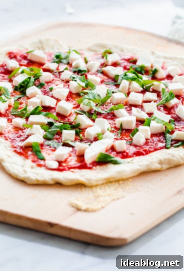 The BEST Homemade Margherita Pizza. Made in a standard kitchen oven! #pizza #margherita #abeautifulplate #recipe #italian Homemade Margherita Pizza on Pizza Peel ready for oven