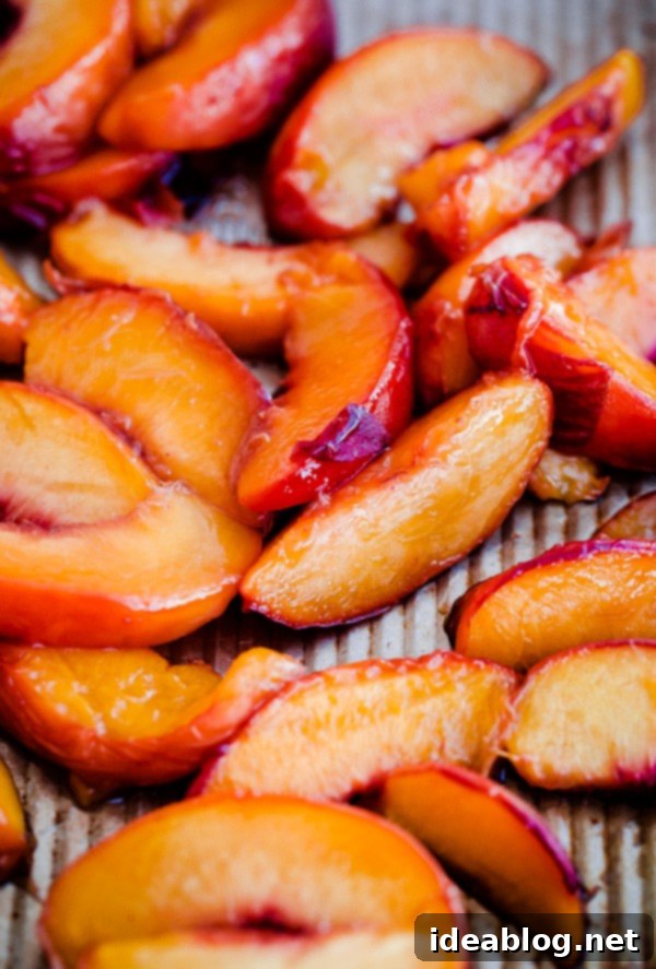 Golden Belgian Waffles with Sun-Kissed Peaches & Vanilla Cloud 3 Close-up of Maple Syrup Roasted Peaches on a baking sheet, glistening and caramelized, ready for topping waffles