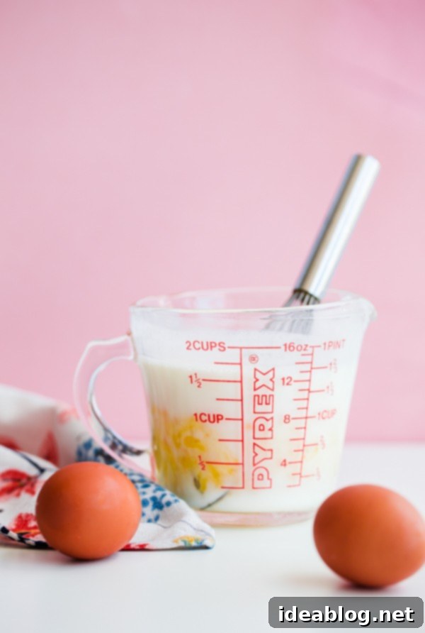 Golden Belgian Waffles with Sun-Kissed Peaches & Vanilla Cloud 4 Buttermilk and eggs in a glass measuring cup, essential ingredients for light and fluffy Belgian waffles