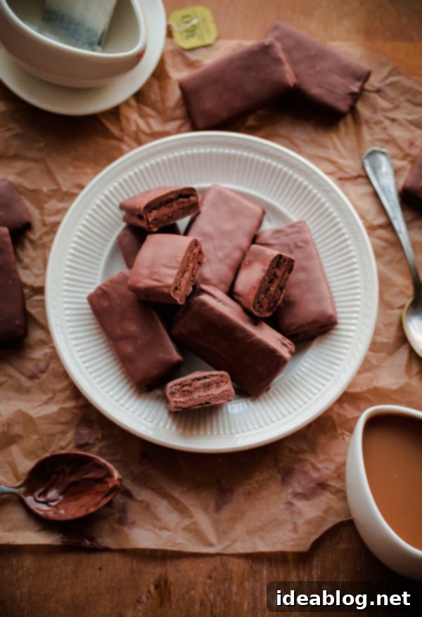 A delicious recipe for homemade Tim Tams - a classic Australian cookie biscuit filled with malted chocolate buttercream and dipped in chocolate. #recipe #chocolate #cookie #timtam #abeautifulplate #dessert Homemade Tim Tam Cookies - A classic Australian chocolate biscuit with malted chocolate buttercream and dipped in milk chocolate