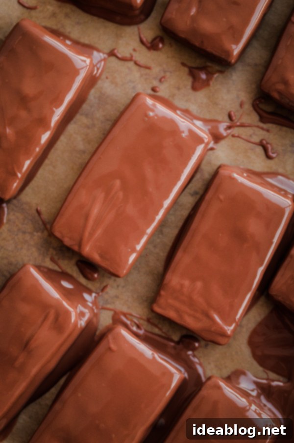 A delicious recipe for homemade Tim Tams - a classic Australian cookie biscuit filled with malted chocolate buttercream and dipped in chocolate. #recipe #chocolate #cookie #timtam #abeautifulplate #dessert Homemade Tim Tams, an iconic Australian cookie
