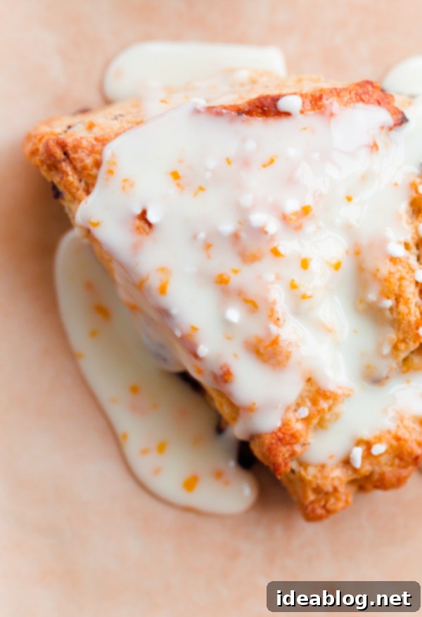 Bright Orange Chocolate Chunk Scones with Zesty Citrus Drizzle 5 A stack of delicious orange chocolate chunk scones topped with a beautiful orange glaze and pearl sugar. A delightful and quick baking project.