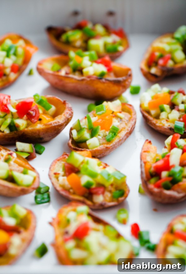 Mediterranean Hummus Potato Boats 2 Greek-Style Potato Skins with Hummus. A HEALTHY and easy potato skin recipe made with hummus, feta, and chopped vegetables - a great party or tailgating appetizer!
