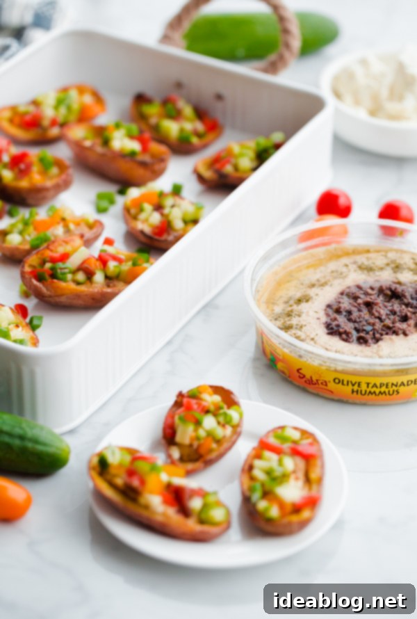 Mediterranean Hummus Potato Boats 6 Greek-Style Potato Skins with Hummus. A HEALTHY and easy potato skin recipe made with hummus, feta, and chopped vegetables - a great party or tailgating appetizer!