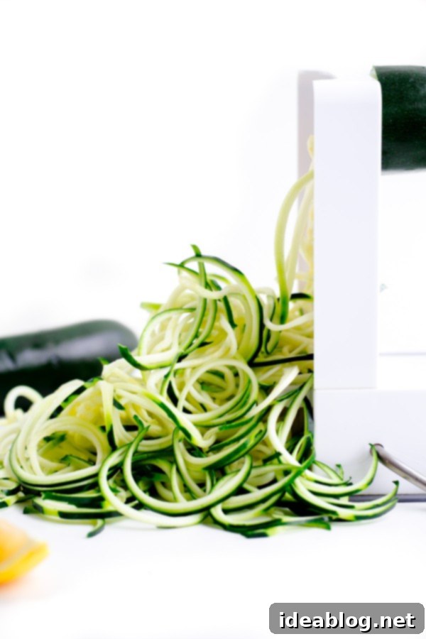 Zucchini Pasta with Garlic Clam Sauce. An EASY, healthy dinner recipe made with zucchini noodles. Less than 250 calories per serving! #abeautifulplate #glutenfree #clam #pasta #zoodles #recipe Inspiralizer tool with a zucchini, showing how easily zucchini noodles are made