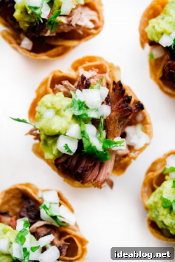 Crispy Slow Cooker Carnitas Taco Bites 2 Delicious Slow Cooker Carnitas Taco Bites with fresh toppings on a serving platter, perfect for parties.