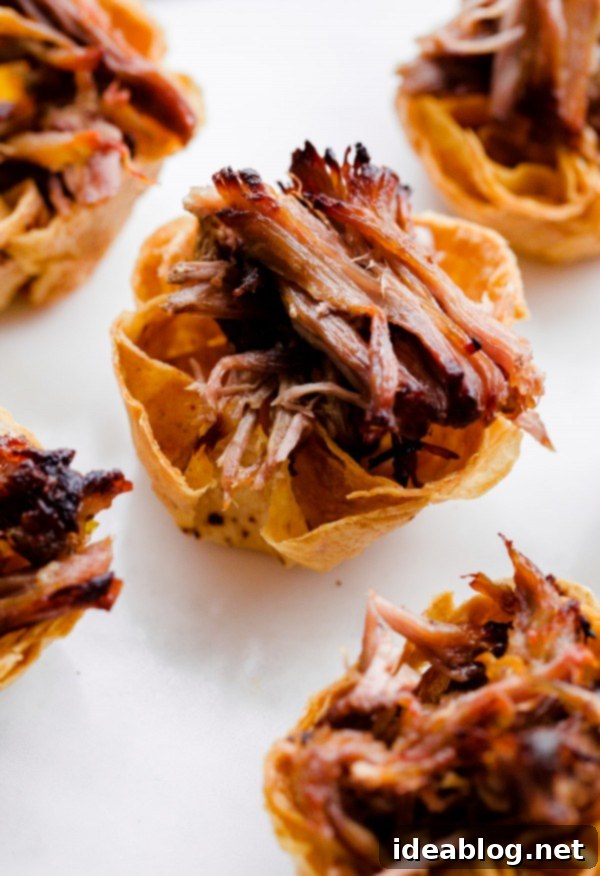 Slow Cooker Carnitas Taco Bites: Crispy mini tortilla cups are key! Homemade crispy tortilla cups filled with slow cooker carnitas and fresh garnishes.
