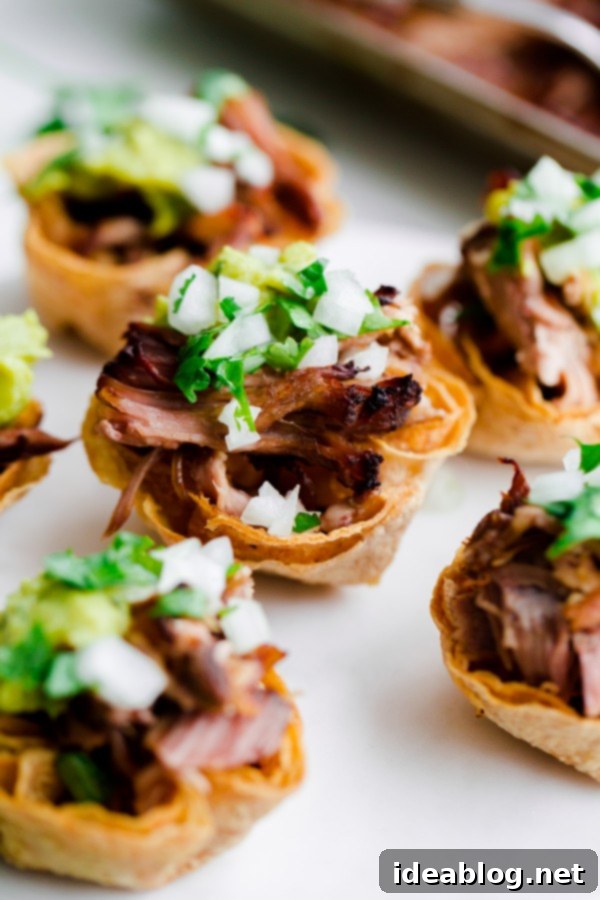 Slow Cooker Carnitas Taco Bites: The ultimate party appetizer. A platter of perfectly assembled Slow Cooker Carnitas Taco Bites, ready to serve.