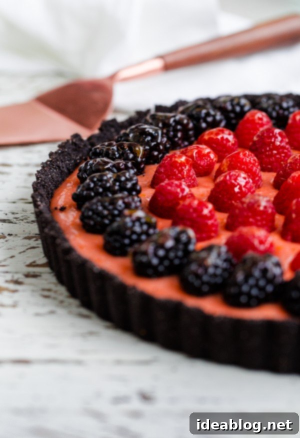 Serving a Stunning Triple Citrus Tart with Fresh Berries Beautiful Triple Citrus Tart with Berries and Chocolate Crust, ready to serve