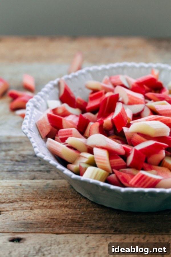 Rhubarb  Close-up of vibrant, freshly chopped rhubarb pieces, glistening with sugar, ready to be added to the galette.