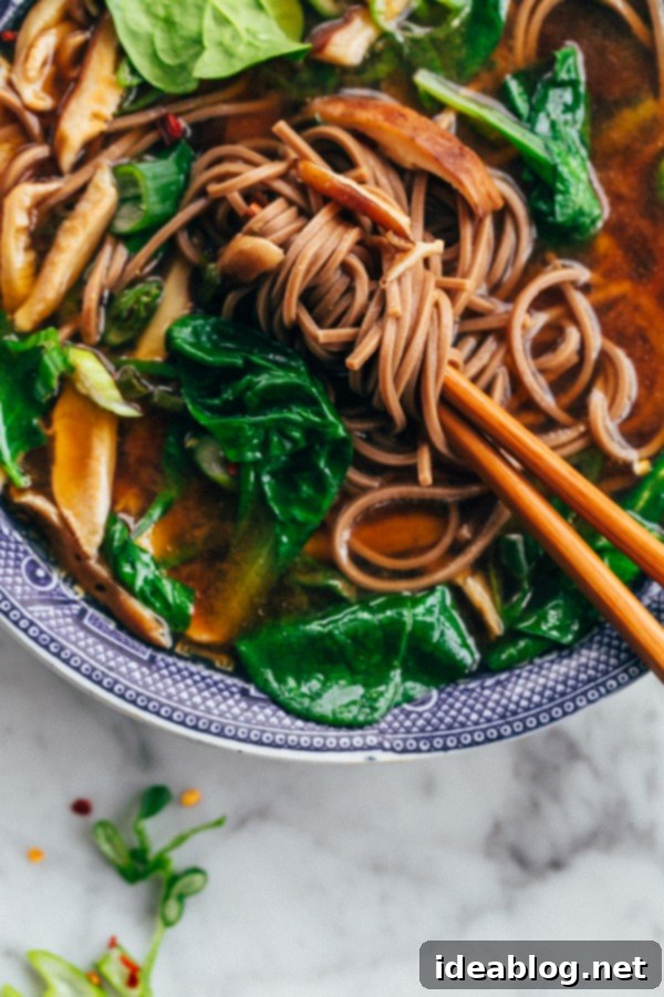 Warm Shiitake and Spinach Miso Soup A spoon dipping into a bowl of homemade shiitake and spinach miso soup.