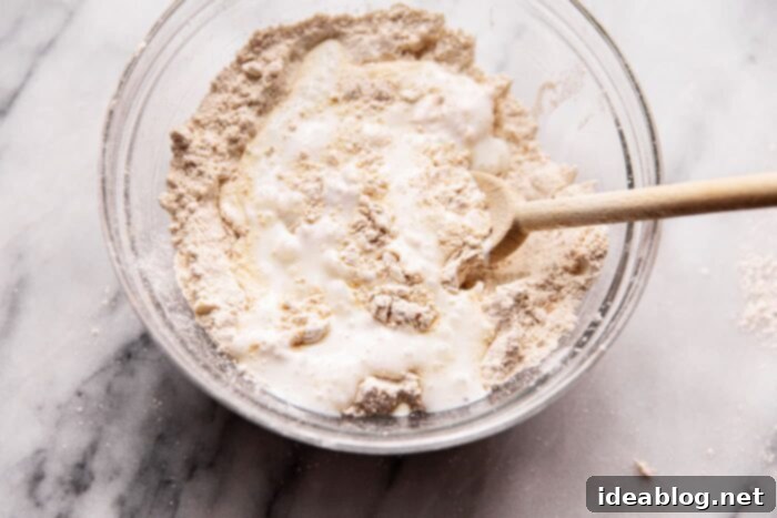 Simple, Wholesome Wheat Biscuits 8 Pouring cold buttermilk into a well of dry ingredients for biscuit dough.
