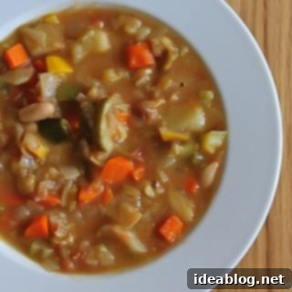 Soul-Soothing Winter Minestrone 4 A close-up of a rustic bowl of Hearty Winter Minestrone Soup, garnished with fresh basil and grated Parmesan cheese.