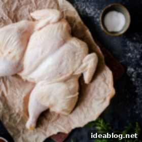 Flat Chicken Big Flavor 10 Spatchcock Chicken resting on a cutting board after being butterflied, ready for seasoning.