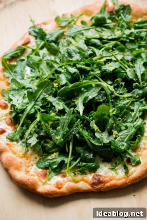 Lemon Truffle Arugula Pizza. A cheese pizza topped with a lemon truffle oil arugula salad! This elegant simple homemade pizza is a crowd favorite!  Lemon Truffle Arugula Pizza