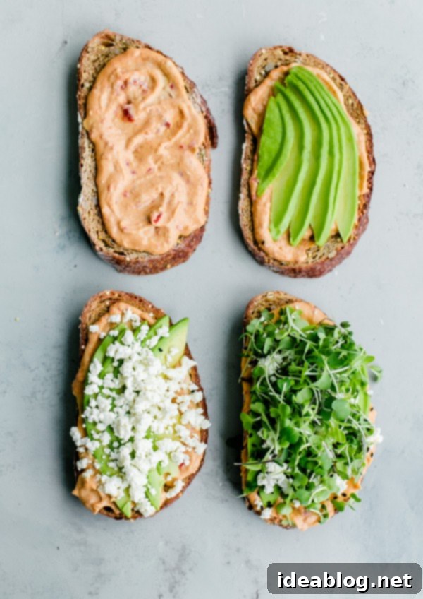 Spicy Hummus Avocado Toast with Feta. An easy vegetarian snack with a spicy kick! #abeautifulplate #vegetarian #feta #hummus #toast #recipe #avocado Two pieces of Spicy Hummus Avocado Toast with Feta and microgreens on a white plate