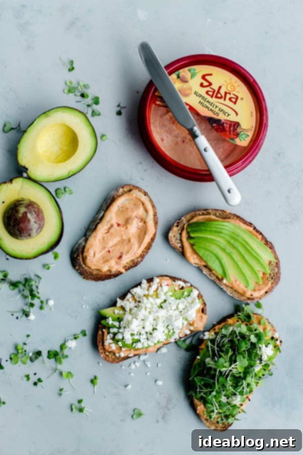 Spicy Hummus Avocado Toast with Feta. An easy vegetarian snack with a spicy kick! #abeautifulplate #vegetarian #feta #hummus #toast #recipe #avocado Close-up of Spicy Hummus Avocado Toast with Feta, garnished with black sesame seeds