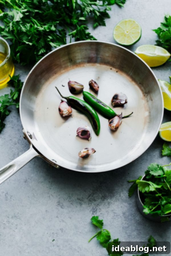 Dry roasting serrano chiles and garlic cloves in a skillet for smoky flavor in your green chile adobo sauce. Dry Roasted Garlic and Serranos for Green Chile Adobo